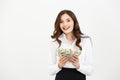 Portrait of a cheerful young business woman holding money banknotes and celebrating isolated over white background. Royalty Free Stock Photo