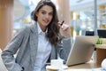 Portrait of a cheerful young businesswoman sitting at the table in office and looking at camera Royalty Free Stock Photo