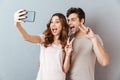 Portrait of a cheerful young couple showing peace gesture Royalty Free Stock Photo