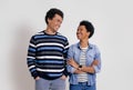 Portrait of cheerful young couple smiling and looking at each other while posing on white background Royalty Free Stock Photo