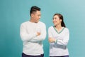 Portrait of a cheerful young couple standing with arms folded and looking at each other isolated over blue background Royalty Free Stock Photo