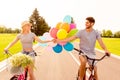 Portrait of cheerful young family having fun and cycling with balloons Royalty Free Stock Photo