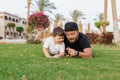 Portrait of cheerful young father lying on grass at park with her little baby son Royalty Free Stock Photo