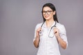 Portrait of cheerful young female doctor with stethoscope over neck looking at camera isolated on grey background Royalty Free Stock Photo