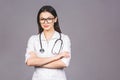 Portrait of cheerful young female doctor with stethoscope over neck looking at camera isolated on grey background Royalty Free Stock Photo