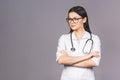 Portrait of cheerful young female doctor with stethoscope over neck looking at camera isolated on grey background Royalty Free Stock Photo
