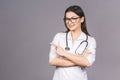 Portrait of cheerful young female doctor with stethoscope over neck looking at camera isolated on grey background. Pointing finger Royalty Free Stock Photo