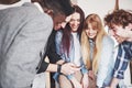 Portrait of cheerful young friends looking at smart phone while sitting in cafe. Mixed race people in restaurant using Royalty Free Stock Photo