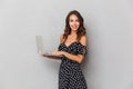 Portrait of a cheerful young girl in dress over gray Royalty Free Stock Photo