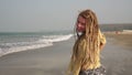 Portrait of a cheerful young hippie downshifter girl with dreadlocks on beach