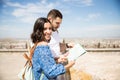 Pretty young woman holding map with boyfriend