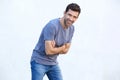 Cheerful young man with arms crossed standing against white wall Royalty Free Stock Photo