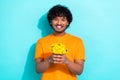 Portrait of cheerful young man holding fresh yellow bouquet daisy flowers send you beautiful present isolated on cyan