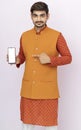 Portrait of a cheerful young man wearing Ethnic indian traditional clothing isolated background, showing blank screen mobile phone
