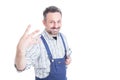 Portrait of cheerful young mechanic with number four gesture Royalty Free Stock Photo