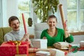 Portrait of cheerful young people, man and woman holding wrapping paper and smiling. Presents preparation Royalty Free Stock Photo