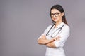 Portrait of cheerful young female doctor with stethoscope over neck looking at camera isolated on grey background Royalty Free Stock Photo