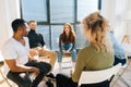 Portrait of cheerful young redhead businesswoman talking and discussing new ideas with creative business team Royalty Free Stock Photo