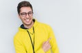 Portrait of cheerful young smiling amazed male model wearing trendy glasses and hoodie, looking at camera and points away, Royalty Free Stock Photo