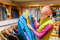 Cheerful young woman choosing items in the sport outdoor hiking store clothes shop Royalty Free Stock Photo
