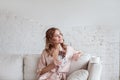 Portrait of a cheerful young woman eating chocolate bar while sitting on sofa and resting at home Royalty Free Stock Photo