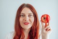 Portrait of a cheerful young woman eating red apple on gray wall background. Healthy nutrition diet. Apple vitamin snack Royalty Free Stock Photo