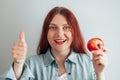 Portrait of a cheerful young woman eating red apple. Healthy nutrition diet. Apple vitamin snack. Royalty Free Stock Photo