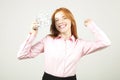 Portrait of cheerful young woman holding bunch of one hundred dollar bills and celebrating in winning pose, hands up raised fist. Royalty Free Stock Photo