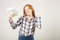 Attractive young businesswoman posing with bunch of USD cash in hands showing positive emotions and happy facial expression. Royalty Free Stock Photo