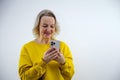 Portrait of cheerful young woman holding mobile phone against white background Royalty Free Stock Photo