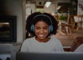 Portrait of cheerful young woman relaxing and listening to music using headphones with laptop Royalty Free Stock Photo