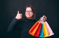 Portrait of cheerful young woman showing thumb up and holding colorful shopping bags Royalty Free Stock Photo