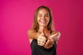 Portrait of a cheerful young woman showing thumbs up sign Royalty Free Stock Photo