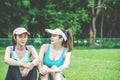 Portrait of cheerful young woman sitting on yoga mat and talking  while having break after training at stadium. Royalty Free Stock Photo