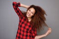 Cheerful young woman smiling with hand in curly hair Royalty Free Stock Photo