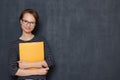 Portrait of cheerful young woman smiling and holding folder and pen Royalty Free Stock Photo