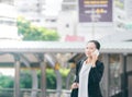 Portrait of cheerful young woman talking on smartphone and laughing outdoors. beautiful aisan business woman using mobile phone Royalty Free Stock Photo