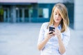 Portrait of cheerful young woman talking on smartphone and laughing outdoors Royalty Free Stock Photo