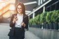 Portrait of cheerful young woman talking on smartphone and laughing outdoors. Happy beautiful caucasian woman using Royalty Free Stock Photo