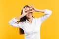 Portrait of cheerful young woman in white casual shirt holding hands near eyes, imitating glasses or binoculars isolated Royalty Free Stock Photo