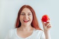 Portrait of a beautiful young woman eating red apple on gray wall background. Healthy nutrition diet. Apple vitamin Royalty Free Stock Photo