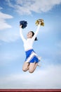 Cheerleader girl jumping with pom poms in park Royalty Free Stock Photo