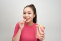 Portrait of a cheery pretty girl eating popcorn isolated over white background Royalty Free Stock Photo