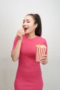 Portrait of a cheery pretty girl eating popcorn isolated over white background Royalty Free Stock Photo