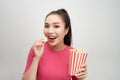 Portrait of a cheery pretty girl eating popcorn isolated over white background Royalty Free Stock Photo