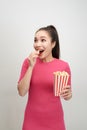 Portrait of a cheery pretty girl eating popcorn isolated over white background Royalty Free Stock Photo