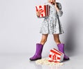 Portrait of a cheery pretty girl holding plastic cup and eating popcorn isolated over white background Royalty Free Stock Photo