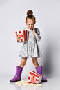 Portrait of a cheery pretty girl holding plastic cup and eating popcorn isolated over white background Royalty Free Stock Photo