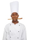 Portrait, chef and black man with spoon in mouth isolated on white studio background. Person, kitchen utensil and