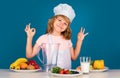 Portrait of chef child in cook hat. Cooking at home, kid boy preparing food from vegetable and fruits. Healthy eating Royalty Free Stock Photo